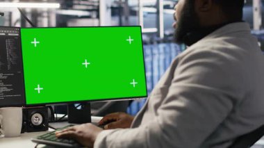 Veri merkezi sistem yöneticisi yeşil ekran PC kullanarak dişlileri denetliyor, bakım görevleri yapıyor. Krom anahtar bilgisayarı kullanan sunucu odası çalışanı, sistem kontrolü yapıyor, kapatıyor