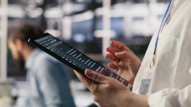 Tablet üzerindeki veri merkezi sistem yöneticisinin kodlamasını kapat, yazılım güncellemeleri yap. Aygıt ekranına bakan sunucu odası bilişim uzmanı, altyapıyı optimize etmek, yapılandırma donanımları, kamera A