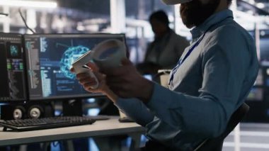 VR kulaklık takan bir veri merkezi çalışanı yapay zeka sinir ağı teknolojisi kullanıyor. Donanım güncellemek için yapay zeka programlama dili ve sanal gerçeklik kullanan sunucu tarım programcısı, kamera A