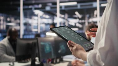 Tablet üzerindeki veri merkezi sistem yöneticisinin kodlamasını kapat, yazılım güncellemeleri yap. Aygıt ekranına bakan sunucu odası bilişim uzmanı, altyapıyı optimize etmek, yapılandırma donanımları, kamera A