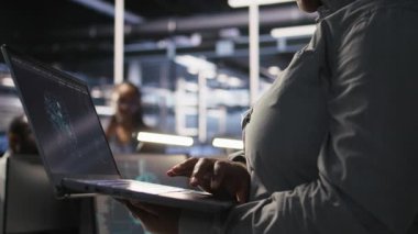 AI LLM görselleştirmesini izlemek için dizüstü bilgisayar kullanarak veri merkezi mühendisliğini kapat. Sunuculara güç veren makine öğrenme süreçlerini denetlemek için dizüstü bilgisayar kullanan işçiler, kamera A