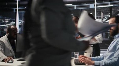 Sunucu çiftliğinde birlikte çalışan yazılım geliştiricileri, sinirsel ağ kodlarını ve LLM görselleştirme panellerini gözden geçiriyorlar. Takım çalışması veri merkezi meslektaşları AI sistem performansını izliyorlar, kamera A