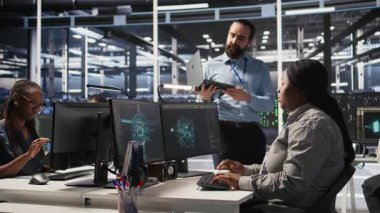 Sinirli veri merkezi çalışanı iş yerindeki anlaşmazlık sırasında meslektaşına kaba bir el hareketi yapıyor. Sunucu merkezindeki kızgın kadın tartışma sırasında iş arkadaşını hiçe sayıyor. Kamera A: