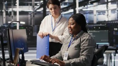 Happy Veri Merkezi Yöneticisi, Yapay Zeka otomasyon araçlarını altyapı bakımına entegre eden ekip çalışmasından memnun. Gülümseyen yönetici işçi güncelleme makinesinden memnun. Öğrenme modelleri, kamera A