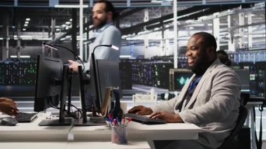 Veri Merkezi Sistem Yöneticisi, sunucuların yapay zeka eğitimi ve çıkarımlarını takip ediyor. Sunucu odasında çalışan adam bilgisayar sistemlerini denetliyor, derin öğrenme işlemlerini yönetiyor, kamera A