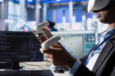 Güneş paneli tesisindeki kadın, VR gözlükleri kullanarak fotovoltaik sistem performansını inceliyor. Verimliliği optimize etmek için sanal gerçeklik teknolojisini kullanarak üretim ölçümlerini analiz eden Afrikalı Amerikalı bir çalışan.