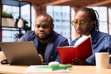 Afrikalı Amerikalı çift, iş eğilimlerini araştırmak ve çevrimiçi bir markayı yönetmek için bir dizüstü bilgisayar kullanarak bağımsız çalışma projesi üzerinde çalışıyor. Başarılı uzaktan kariyer geliştirme.