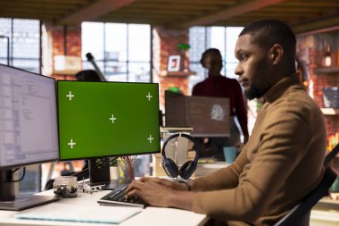 Başlangıç ofisinde yeşil ekran PC kullanan bilişim mühendisi ve uygulama geliştirmek için programlama dilleri kullanıyor. Yazılım geliştirme ajansı çalışanı, model bilgisayarda kodu optimize ediyor