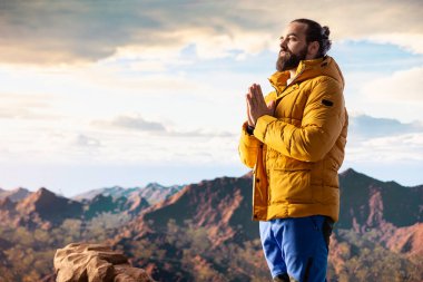 Huzurlu bir kâşif, stres atmak için meditasyon yapıyor. Dağın tepesinde rahatlık ve denge için dinleniyor. Genç gezgin, dikkat çekmek için meditasyon yapıyor..