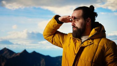 Manzaralı bir bakış açısında duran erkek kaşif dağların barışçıl güzelliğini takdir ediyor ve başarılı bir tırmanış yapıyor. Trekker yüksek irtifaya, özgürlüğe ve zihinsel açıklığa hayran. Kamera A.