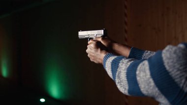 Atış poligonu müşterisi silahla ateş ediyor, uzun menzilli hedeflerle çatışmaya giriyor. Afrika kökenli Amerikalı adam ateş ederek öldürücü bir silah kullanıyor. Koruyucu ekipman ve kamera takıyor.