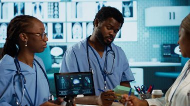 Önlüklü erkek ve kadın hemşireler uzman doktor, bakım yönetimi ile profesyonel eğitim ve araştırma yapmaktadırlar. Sıhhiye onlara ilaç ve ilaç stoğu sunuyor. Kamera A.