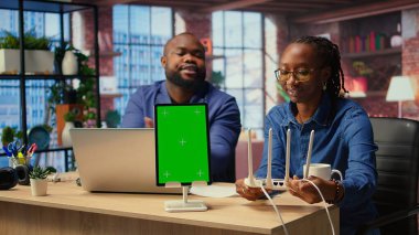 Kopya alanının yanındaki kablosuz ağ kurulumunu tamir ederken kavga eden Afrikalı Amerikalı çift serbest meslek yaşamlarında verimliliklerini korumak için sorun çıkaran yönlendirici hatalar yapıyor. Kızgın serbest çalışanlar. Kamera A.