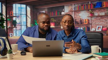 Olgun çift evlerinde online bankacılık ile uğraşıyorlar, ödemeleri ayarlıyorlar ve para transferini onaylıyorlar. Memnun erkek ve kadın dizüstü bilgisayardan alışveriş yapıyor. Kamera A.