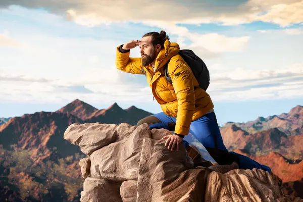 Yürüyüş yolcusu, tepedeki panoramik dağ manzarasına, sonsuz gökyüzüne ve kayalık tepelere hayranlık duymak için ara verir. Zihinsel berraklık için nefes kesici bir zemin oluşturur. Dışarıdaki maceracı..