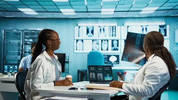 Afrika kökenli Amerikalı kadın doktor, rutin kontrol ziyareti sırasında bir kıza radyoloji sonuçlarını açıklıyor. Teşhis ve tedavi tavsiyelerine odaklanıyor. Özel bir klinikte etkili iletişim. Kamera B.