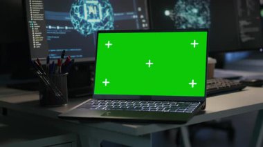 Sunucu çiftliğindeki izole ekran laptopu yapay zekayı izliyor sinirsel ağların verilerini ve analizlerini görselleştiriyor. Sunucuları denetleyen, makine öğrenme işlemlerine güç veren bir defter.