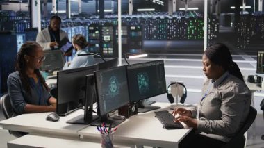 Veri merkezi sistem yöneticisi PC kullanarak nöral ağ yapay zeka görüntülemesini izliyor. Sunucu odasında Afrika kökenli Amerikalı bir kadın bilgisayarla donanımlı makine öğrenme işlemlerini denetliyor. Kamera A