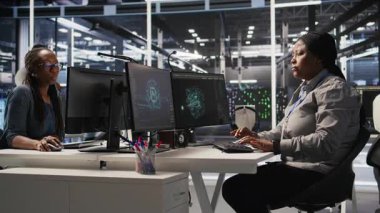 Veri merkezi geliştirici kodlaması PC 'de, yapay zeka süper bilgisayarları için yazılım güncellemeleri yapıyor, saate bakıyor. Sunucu çiftliği bilişim uzmanı yapay zeka ve kamera A kullanarak altyapıyı optimize ediyor.