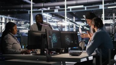 Sunucu odasında beyin fırtınası yapan programcılar, sinirsel ağ kodlarını ve LLM görselleştirme panellerini gözden geçiriyorlar. Veri Merkezi çalışanları yapay zeka sistemlerinin performansını izliyorlar, kamera A