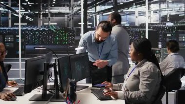 Sunucu odası yöneticisi AI eğitim verilerini yöneten çalışanlara geri bildirim sağlıyor. Ekip lideri Veri Merkezi 'ndeki teknisyenle konuşuyor. Sinir ağlarını destekleyen sistem operasyonlarını denetliyor. Kamera A