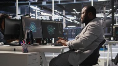 Bilgisayar masasında uzun süre oturduktan sonra yorgun sunucu çiftliği çalışanı geriliyor. Veri merkezindeki yorgun adam kaslarını gevşetiyor, uzun donanım sorun çözme seansından dolayı stresli, kamera A