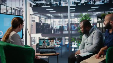 Çok ırklı iş adamları ofis lobisinde bir web video konferansına katılarak, küresel çok kültürlü bir çalışma ortamında uzak ortaklarla strateji ve müzakere noktaları alışverişinde bulundular. Kamera A.