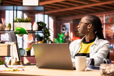 Düşünceli kadın pencereden dışarı bakmak için işe ara veriyor, sıkılmış hissediyor. Afro-amerikalı bir insan evde hayal kuruyor, dizüstü bilgisayara çok fazla baktıktan sonra gözlerini dinlendiriyor.