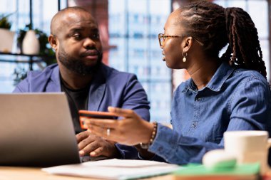 Çevrimiçi ödeme yapmadan önce bakiyeyi doğrulamak için kart numaralarını girenler ve evdeki internet sayfalarında ticaret yapanlar. Genç bir çift internet alışverişi yapıyor ve para transfer ediyor. Alışveriş..