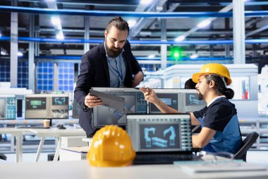 Photovoltaics fabrika müdürü işçilere üretim akışını nasıl optimize edeceğini göstermek için tablet kullanıyor. Sürdürülebilir enerji güneş panelleri fabrika denetleyicisi üretim sürecini izlemek için çalışan aygıtı verir