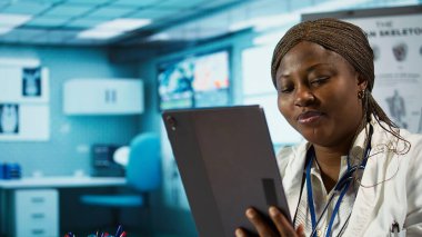 Kayıt ve tedavi planlarından elde edilen verileri inceleyen kadın doktor, sağlık sektörünü iyileştirmek ve hastalıklı insanlara yardım etmek için. Afrikalı Amerikalı sıhhiyeci, sağlık hizmeti sağlayıcısı olarak araştırma yapıyor. Kamera B.