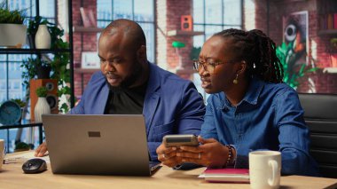 Siyahi adam ve kadın finansal belgeleri analiz ediyor ve masrafları, gelir ve tasarruf yönetimini takip ediyor. Vergi ödemeye ve ev bütçesini planlamaya hazırlanan çift. Kamera A.