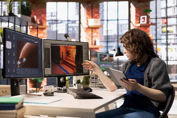 Kadın oyun geliştirici bilgisayar üzerinde yapay zeka destekli asistan ile etkileşime girer, otomasyonu kullanarak bir bilgisayar oyunu ortamı yaratmaya yardımcı olur. Yaratıcı görevler için kullanılan makine öğrenimi.