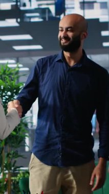 Bir müzakere toplantısında birbirlerine hoş geldin diyen çok kültürlü CEO 'lardan oluşan dikey video grubu, uluslararası şirketleri arasında yeni ve başarılı bir ortaklığın detaylarını tartışıyor.