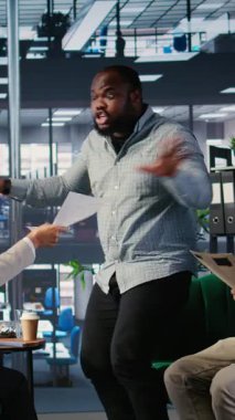 Yatırım kararları konusunda iş adamlarının yer aldığı bir kurumsal ofiste dikey video tartışması, cinsiyet eşitliği endişelerini ve karar vermedeki profesyonel zorlukları yansıtıyor. Kamera A.