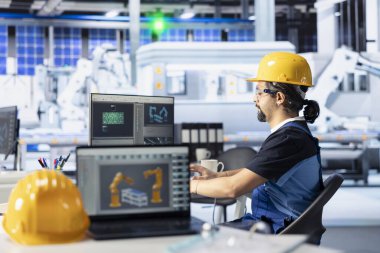 Güneş panelleri, bilgisayar ekranındaki özellikleri inceleyerek yüksek verimliliği sağlayan bitki kalite kontrol uzmanı. PC 'de montaj hatlarını ayarlayan fotovoltaik fabrikası teknisyeni.