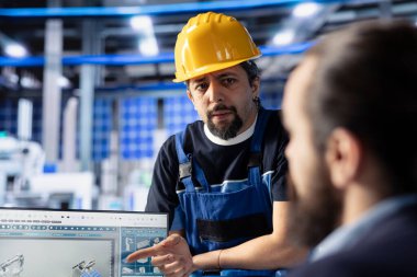Güneş paneli mühendislik ekibi fotovoltaik sistem performansını inceliyor. İş arkadaşları verimliliği optimize etmek için endüstriyel fabrika ofisindeki üretim ölçümlerini analiz ediyorlar.