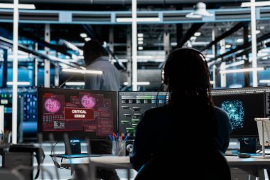 Sunucu odası uzmanı bilgisayardan kritik hata bildirimi alırken, yapay zeka kullanarak arıza süresini azaltıyor. Hata ile ilgilenen yönetici, veri merkezinde yapay zeka uygulanırken uyarı iletisi alıyor