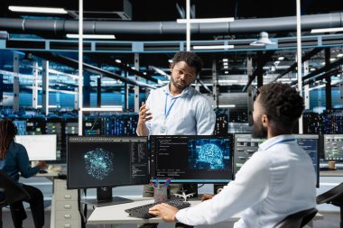 Veri merkezi yöneticisi, veri tabanlarını analiz etmek için derin öğrenme algoritmaları kullanan mühendis tarafından yapılan çalışmaları denetliyor. Sunucu tarım ekibi lideri veri kalıplarını tanımlamak için yapay zeka teknolojisini kullanarak çalışanı denetliyor