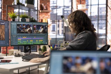 Genç kadın video editörü yaratıcı ajanslarda çift monitörlerle çalışıyor, video görüntülerini düzenliyor ve yaratıcı süreç için renk sınıflandırması yapıyor. İçerik oluşturmak için prodüksiyon gönder.