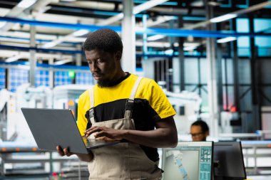 PC tabanlı güneş uzmanları üretim fabrikasındaki otomasyon verilerini gözden geçiriyorlar. Üretim endüstrisi yenilenebilir enerjiye odaklanıyor. Güneş panellerini ve makine performansını izleyen mühendis.