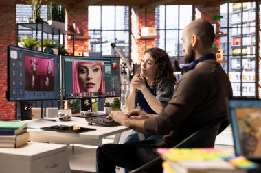 Grafik tasarımcı ve fotoğrafçı, bir PC üzerinde yapay zeka destekli fotoğraf düzenleme yazılımı kullanarak modern bir stüdyoda işbirliği yapmaktadır. Otomasyon, rötuş ve gelişmiş görüntü ayarlama araçları sağlanıyor.