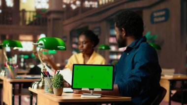 Siyahi akademik öğrenciler, bir halk kütüphanesinde eğitim başarısı için, araştırma notları ve kitaplardan edinilen bilgileri okuyarak, modelin yanında eğitim başarısı için eğitim görüyorlar. Öğrenci takımı test için hazırlanıyor. Kamera B.