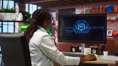 Kendi kendini öğrenme algoritmalarıyla insan beynini simüle eden yapay zeka hesaplaması için evdeki bilgisayarı kullanan programcı. Masaüstü bilgisayarı, kamera A 'da yapay zeka ile çalışan çalışanlar.