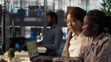 Genel müdür, proje geliştirme ve kurumsal hedefler üzerine bir oturuma öncülük eden bir çalışanla birlikte mali tahminleri gözden geçiriyor. İş amaçlarına ulaşmak için işbirliği yapmak. Kamera A.