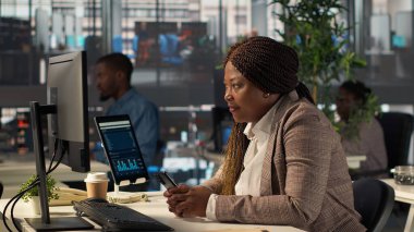 Siyahi iş adamları sosyal medya sitelerine girip ofisteki birkaç mesaja kısa bir ara veriyor. Kadın işçi mesajlaşma yoluyla çevrimiçi iletişim kuruyor. Kamera A.