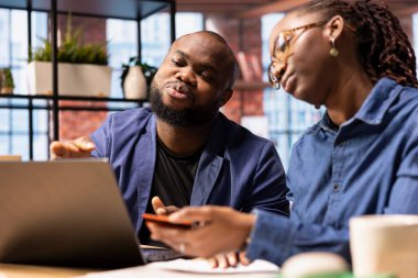 Gençler bir şey almadan ya da ödemeden önce bakiyeyi kontrol etmek için kart kullanıyorlar. Afrikalı Amerikalı erkek ve kadın uzaktan internet alışverişi yapıyorlar..