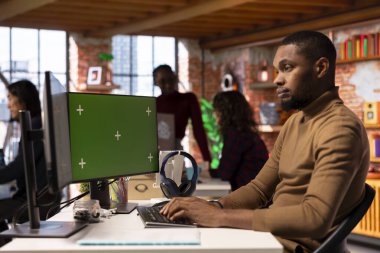 Girişim girişimcisi araştırma yapmak için yeşil ekran PC kullanıyor, şirketin değerini artırmaya çalışıyor. Afrika kökenli Amerikalı girişimci işletme yöneticisi model bilgisayar kullanarak, yenilikçi büyüme stratejisi geliştiriyor