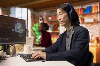 Yapay zeka uygulaması oluşturulurken müzik dinleyen bir teknoloji şefi. Yapay zeka yazılım geliştirme ajansında çalışırken kulaklık takan kıdemli geliştirici