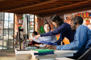 Çağrı merkezi müdürü, müşteri memnuniyetini değerlendirerek çok ırklı takım performansını değerlendiriyor. Müşteri hizmetleri müfettişi çok ırklı iş arkadaşlarını denetliyor.